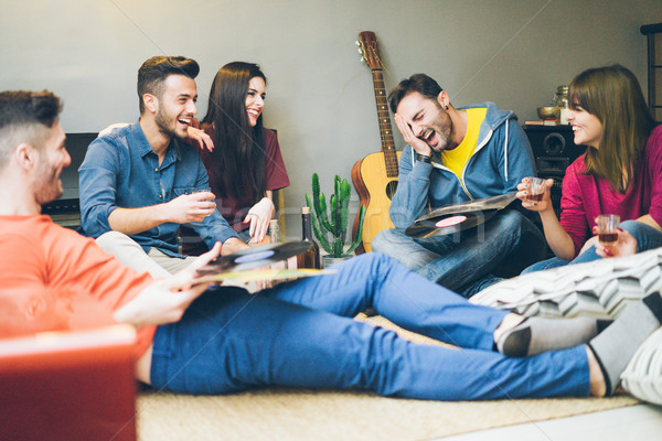 Happy friends having fun in home living room drinking and laughi Stock photo © DisobeyArt