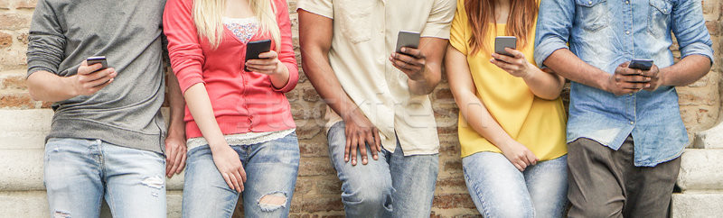 Stock photo: Diverse culture students watching smart mobile phones in univers
