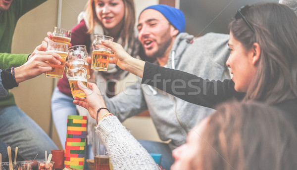 Happy friends cheering with beer and playing board games in bar  Stock photo © DisobeyArt