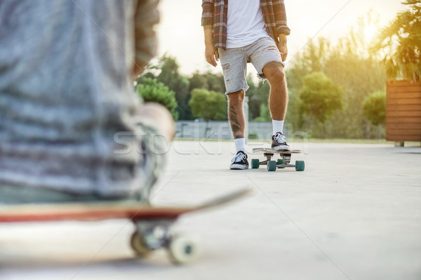 Two skateboarders training in skate park at sunset - Close up of Stock photo © DisobeyArt