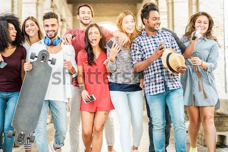 Group of young multiracial friends using smartphones on city con Stock photo © DisobeyArt