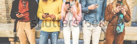 Boldog többnemzetiségű barátok néz okos mobiltelefonok Stock fotó © DisobeyArt