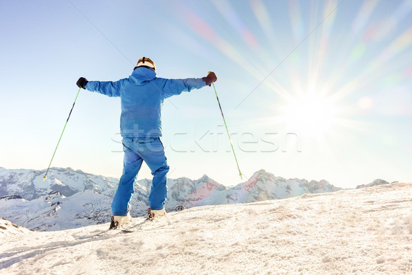 Young skier at the top of mountain raising arms at sky for goal  Stock photo © DisobeyArt