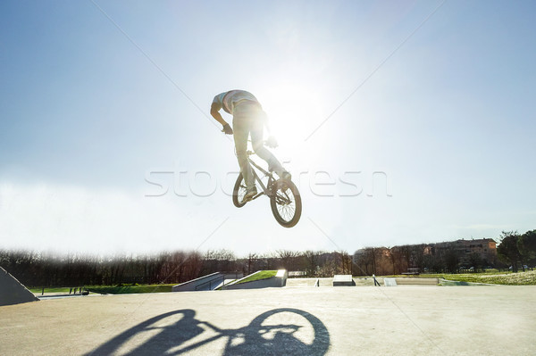 Bmx biker jumping against the sun in city skate park outdoor - Y Stock photo © DisobeyArt