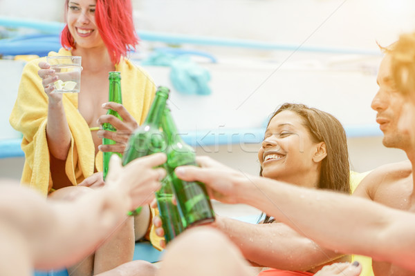 Group of friends cheering and toasting beer and cocktails in swi Stock photo © DisobeyArt