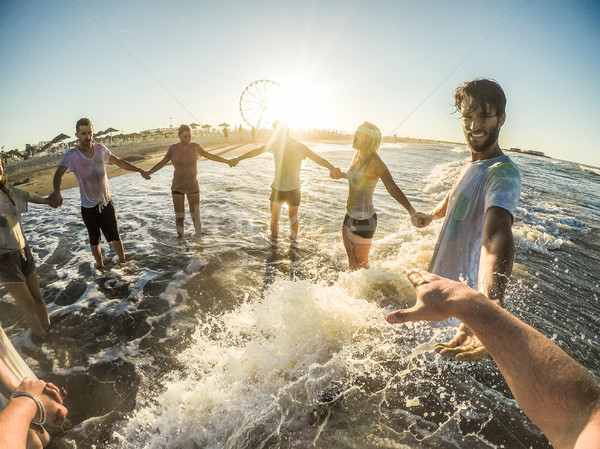 Stock photo: Firsthand view of happy friends having fun on the beach at sunse