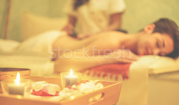 Young woman having hot stone therapy massage in spa resort hotel Stock photo © DisobeyArt