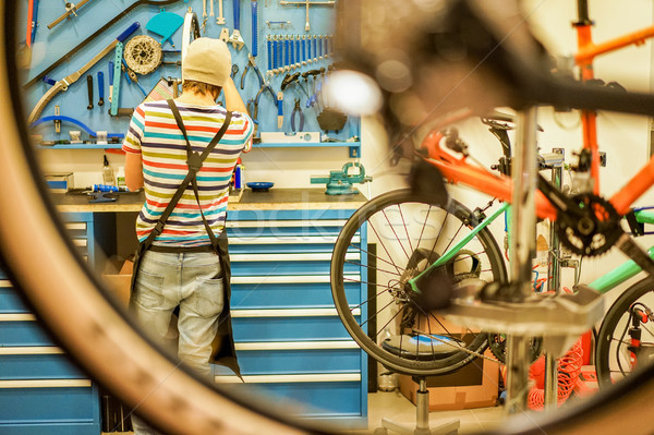 Owner bike mechanic preparing racing bicycles in workshop - Youn Stock photo © DisobeyArt