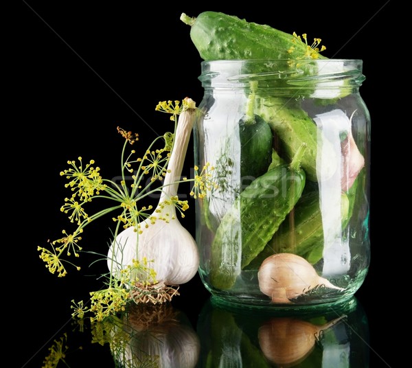 Cucumbers in jar preparate for preserving on black Stock photo © dla4