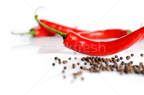 Perspective view of chilli pepper and black pepper on white Stock photo © dla4