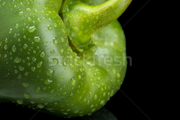 Cut shot of green bell pepper isolated on black with water drops Stock photo © dla4