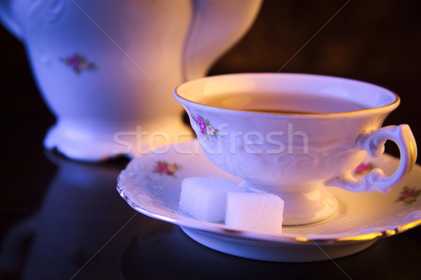 Old-style kettle with cup of tea on black Stock photo © dla4