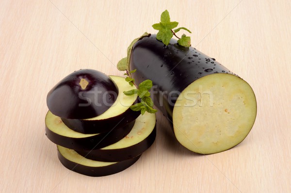 Sliced aubergine, eggplant with mint leaves on bright wooden table Stock photo © dla4