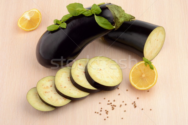 Sliced eggplants basil leaves,lemons,black pepper on bright wooden table Stock photo © dla4