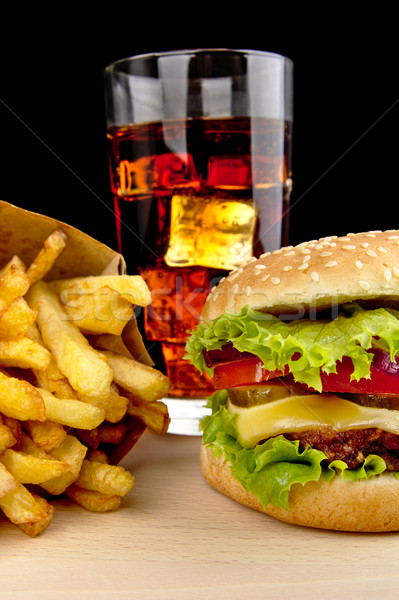 Menu of cheeseburger,french fries,glass of cola on wooden desk on black Stock photo © dla4