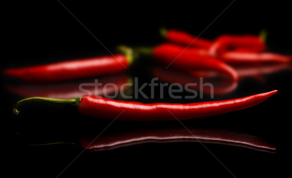Studio shot of chilli peppers on black Stock photo © dla4