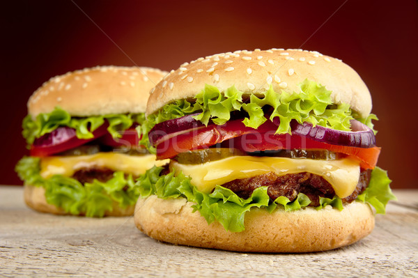 Cheeseburgers on wooden table on burned background Stock photo © dla4