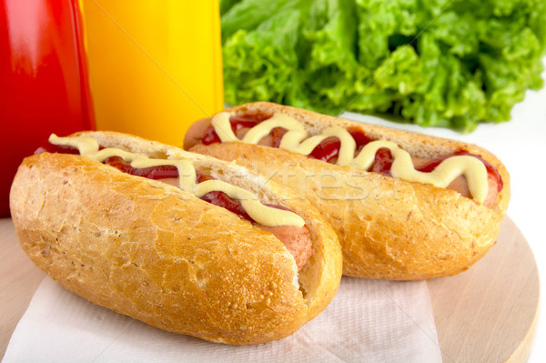 Hotdog with bottle of mustard and ketchup with salad on wooden d Stock photo © dla4