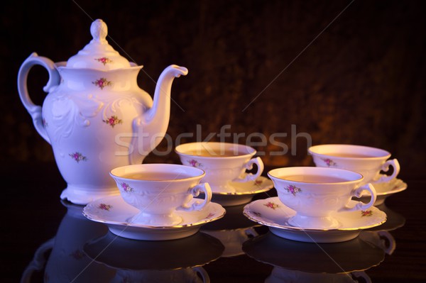 Kettle with four cups of tea on black background Stock photo © dla4