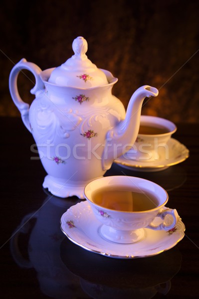 Old-style kettle with two cups of tea on black Stock photo © dla4