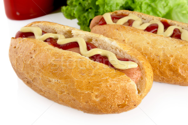 Hotdogs with ketchup with lettuce in the background on white Stock photo © dla4
