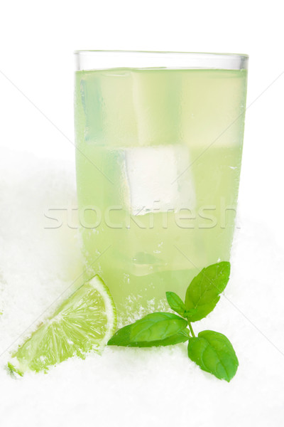 Glass of lime juice with ice cubes on snow on white Stock photo © dla4