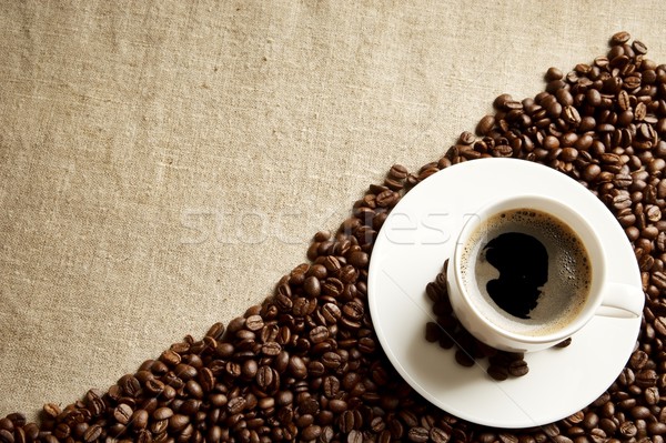 Frothy coffee cup with beans in the corner on fabric flax Stock photo © dla4