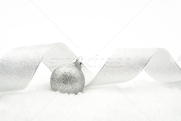 Silver christmas glittering bauble with ribbon on snow Stock photo © dla4