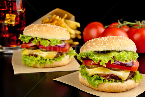 Cheeseburgers,french fries on wooden desk on black Stock photo © dla4