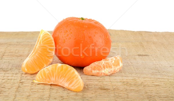 Mandarine with pieces isolated on wooden table Stock photo © dla4