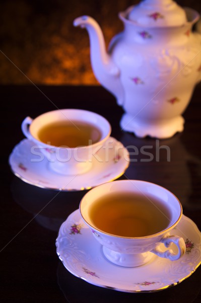 Old-style kettle with two cups of tea on black Stock photo © dla4