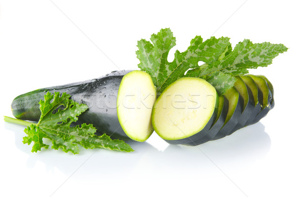 Courgette cut into slices and leaves on white Stock photo © dla4