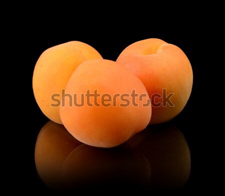 Three whole apricots isolated on blac Stock photo © dla4
