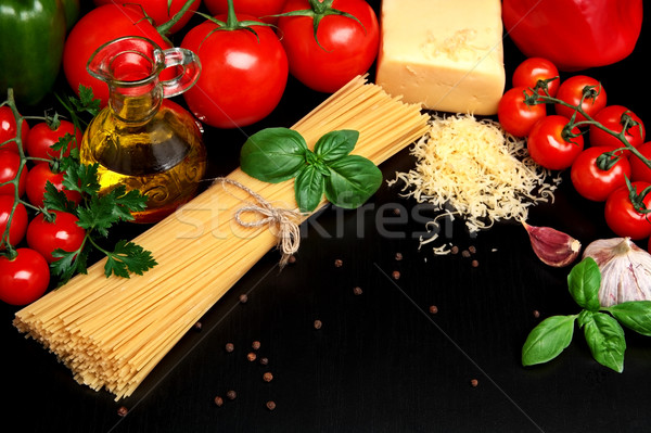 Pasta raw isolated on black with tomatoes,olive oil,garlic Stock photo © dla4