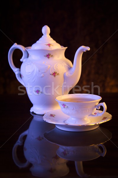 Old-style kettle with cup of tea on black Stock photo © dla4