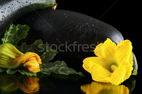 Wet courgettes with flowers on black background Stock photo © dla4