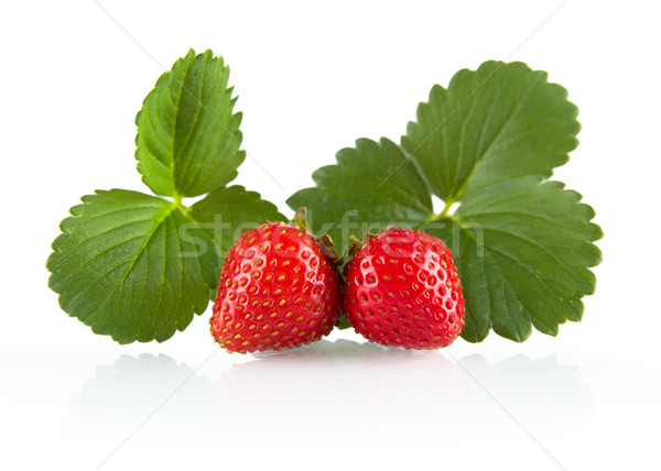 Two whole strawberries with leaves isolated on a white Stock photo © dla4