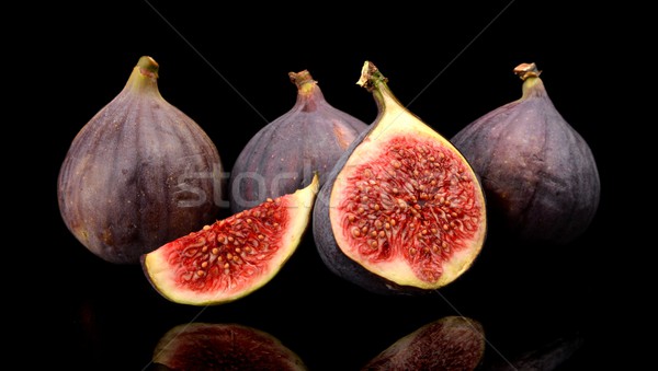 Group sliced figs isolated on black background  Stock photo © dla4