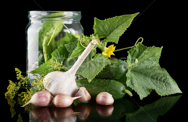 Cucumbers in jar preparate for pickling on black Stock photo © dla4
