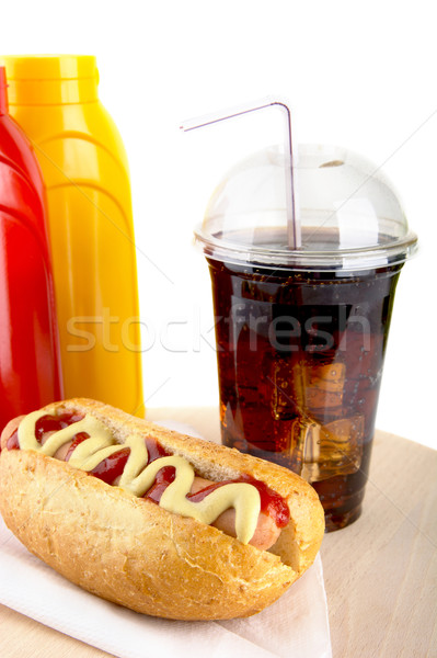 Hotdog with cola and bottle of mustard and ketchup on wooden desk Stock photo © dla4