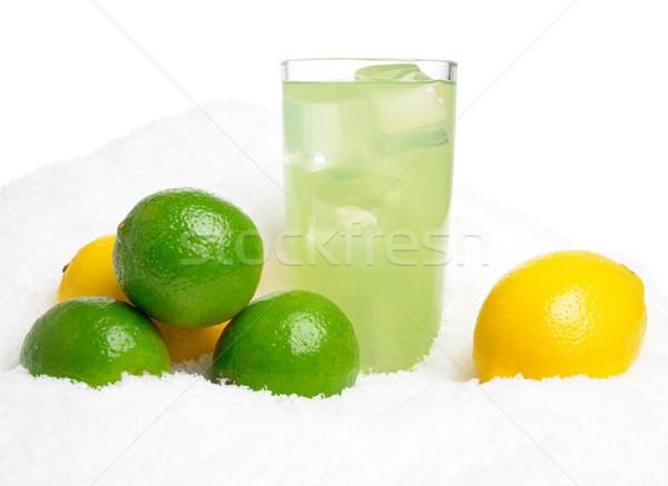 Glass of lime juice with ice cubes,limes,lemons on snow on white Stock photo © dla4