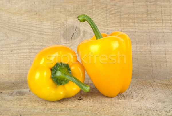 Studio shot of yellow bell peppers on wooden plank Stock photo © dla4