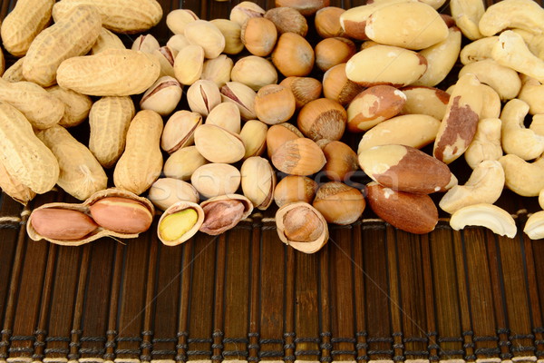 Close up shot of many nuts from above on brown mat Stock photo © dla4