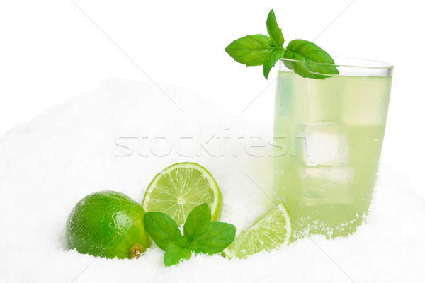 Glass of lime juice with ice cubes on snow on white Stock photo © dla4