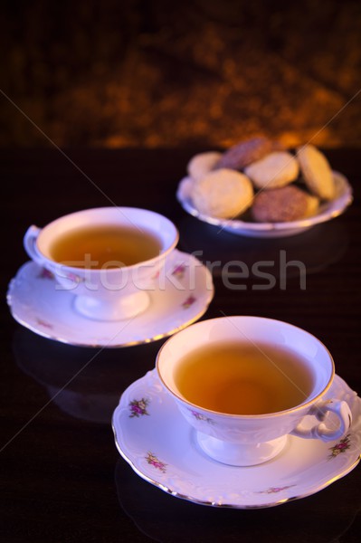 Old-style kettle with two cups of tea with cookies on black Stock photo © dla4