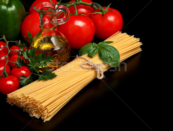 Pasta raw isolated on black with tomatoes,olive oil,garlic Stock photo © dla4