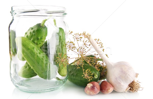 Stock photo: Cucumbers in jar preparate for preserving on white
