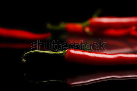 Studio shot of chilli peppers on black Stock photo © dla4