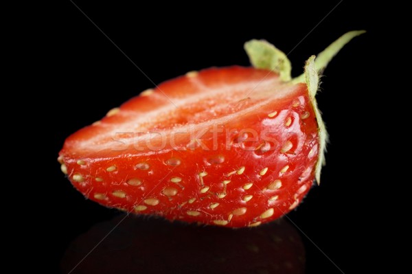 Macro side view of half of strawberry isolated on black Stock photo © dla4