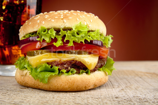 Big cheeseburger with glass of cola on red spotlight Stock photo © dla4
